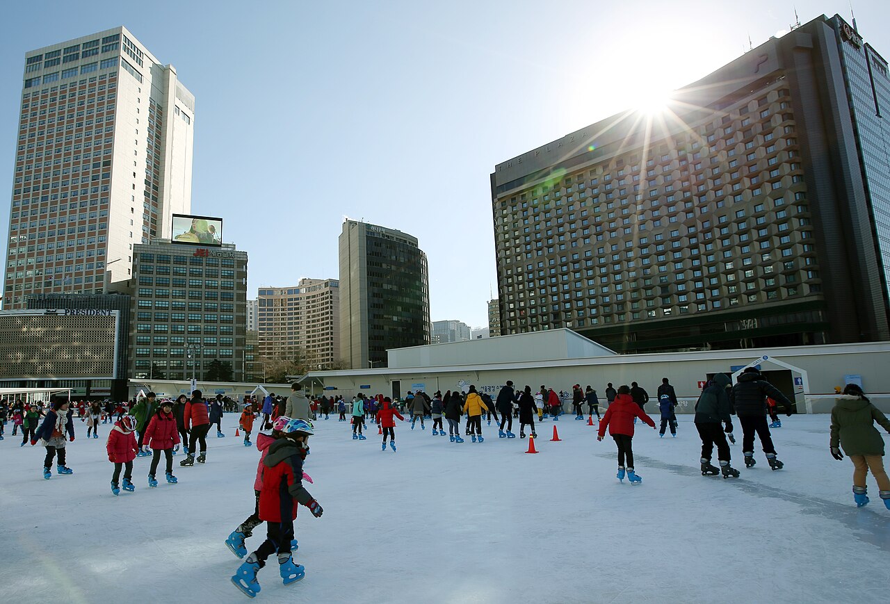 Personas patinando en la pista de hielo al aire libre de la plaza de Seúl
